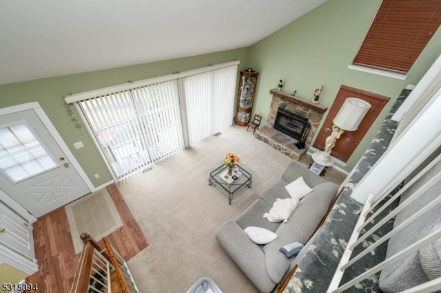 living room featuring vaulted ceiling, hardwood / wood-style flooring, and a fireplace