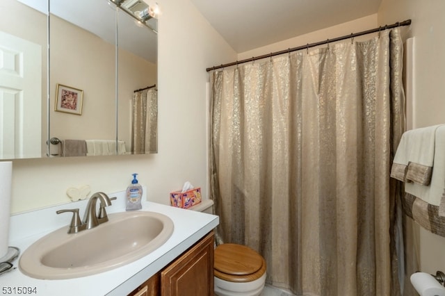 bathroom featuring walk in shower, vanity, and toilet