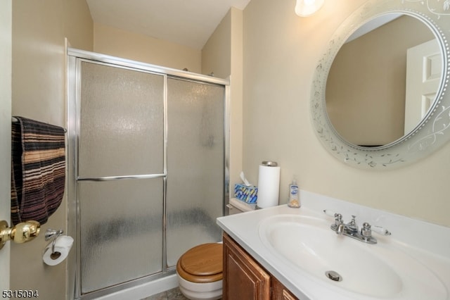 bathroom with walk in shower, vanity, and toilet