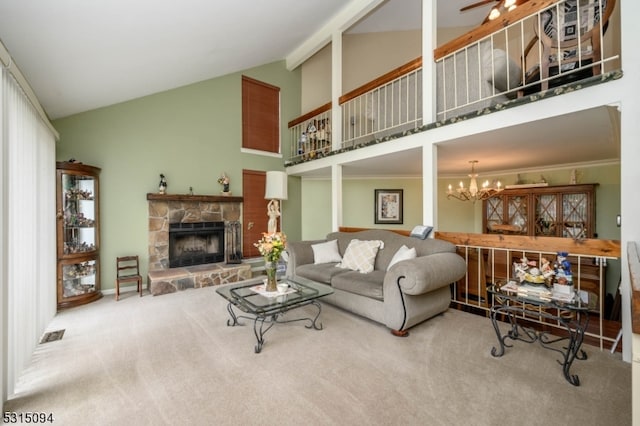 living room with carpet, a stone fireplace, ornamental molding, and high vaulted ceiling