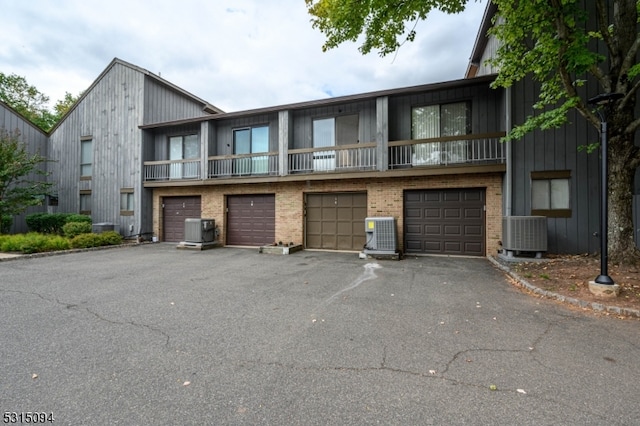 multi unit property with a balcony, a garage, and central AC unit