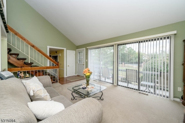 carpeted living room with high vaulted ceiling