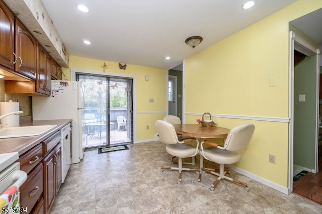 kitchen featuring decorative backsplash, white appliances, and sink