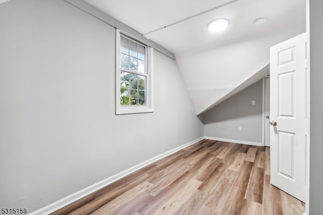 bonus room featuring lofted ceiling and light hardwood / wood-style floors