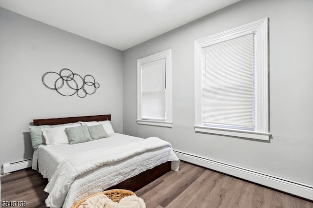 bedroom with wood-type flooring and a baseboard radiator