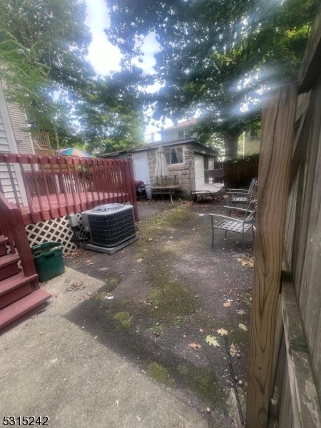 view of yard with a wooden deck and central AC unit