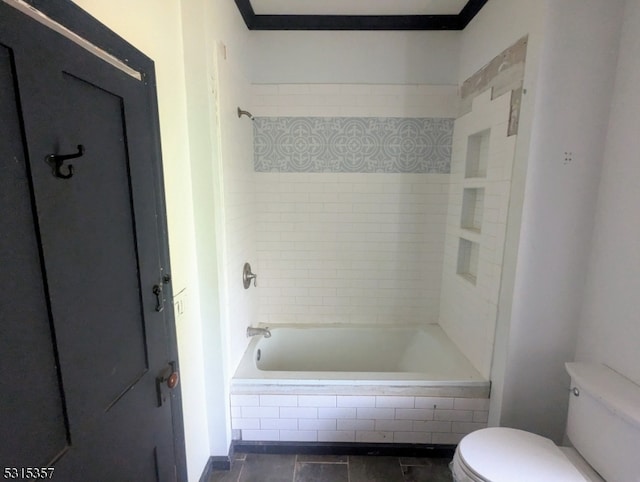 bathroom featuring tiled shower / bath combo, toilet, crown molding, and tile patterned floors