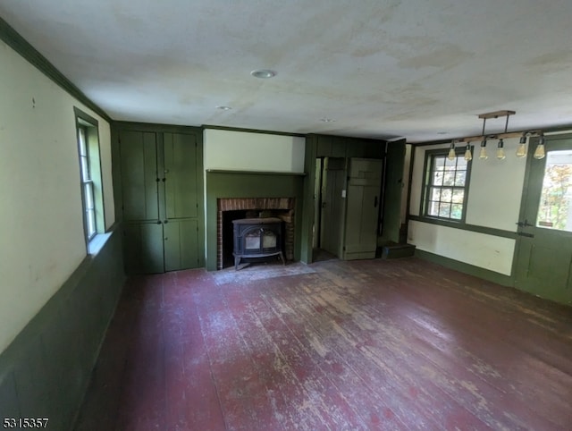 unfurnished living room featuring a wood stove, a fireplace, and dark wood-type flooring