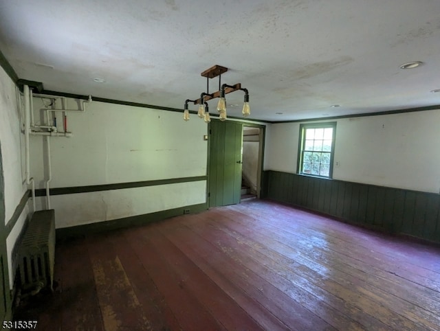 unfurnished room with radiator and hardwood / wood-style flooring