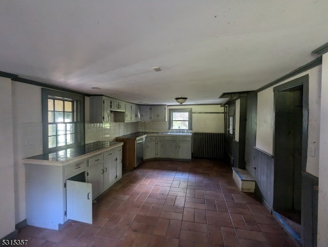 kitchen with sink, backsplash, crown molding, and stainless steel dishwasher