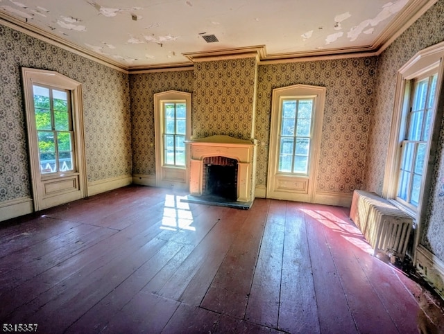 unfurnished living room featuring a brick fireplace, hardwood / wood-style floors, and crown molding