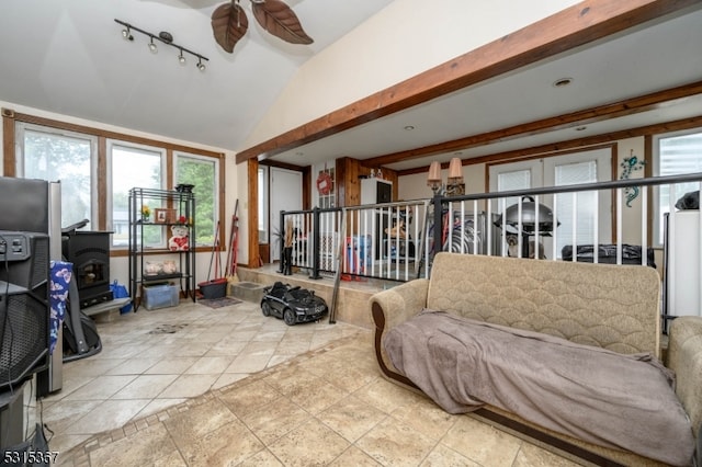 tiled living room featuring ceiling fan, lofted ceiling, and a wood stove