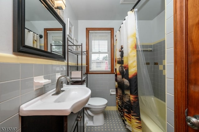 full bathroom with vanity, tile walls, shower / bath combo with shower curtain, and toilet