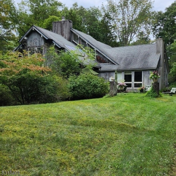 rear view of property featuring a yard