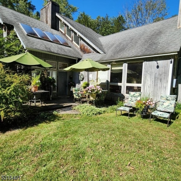 rear view of house with a patio and a yard