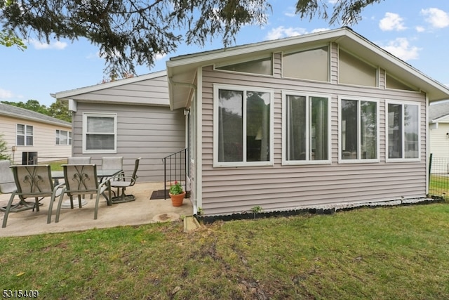 rear view of property featuring a patio area and a yard