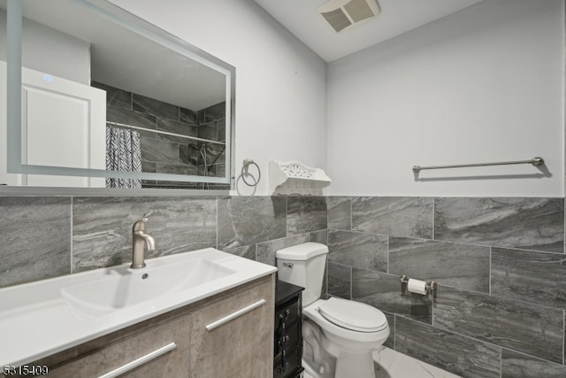 bathroom with walk in shower, tile walls, vanity, and toilet