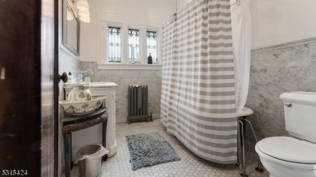 bathroom with toilet, tile walls, radiator, and a shower with shower curtain