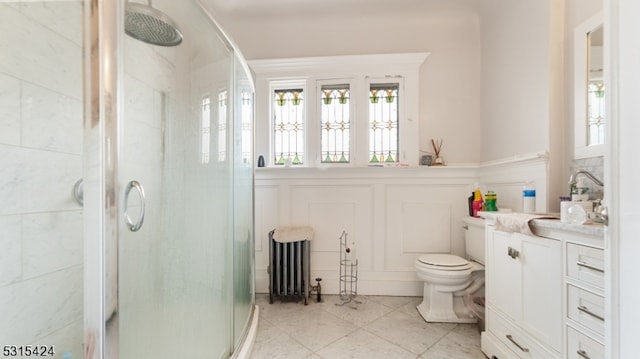 bathroom featuring tile patterned floors, toilet, vanity, radiator heating unit, and walk in shower