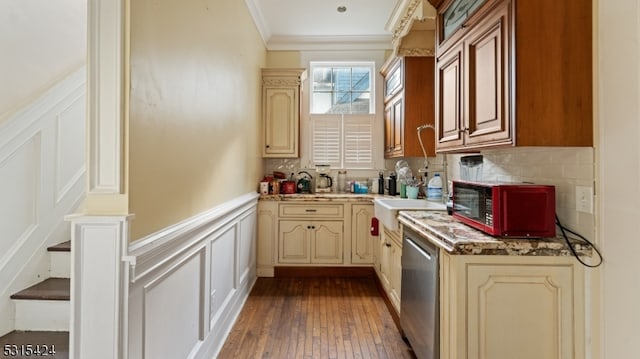 kitchen featuring tasteful backsplash, wood-type flooring, ornamental molding, dishwasher, and sink