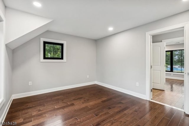 additional living space featuring baseboards, recessed lighting, lofted ceiling, and dark wood finished floors