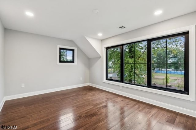 bonus room with wood finished floors, baseboards, and a wealth of natural light
