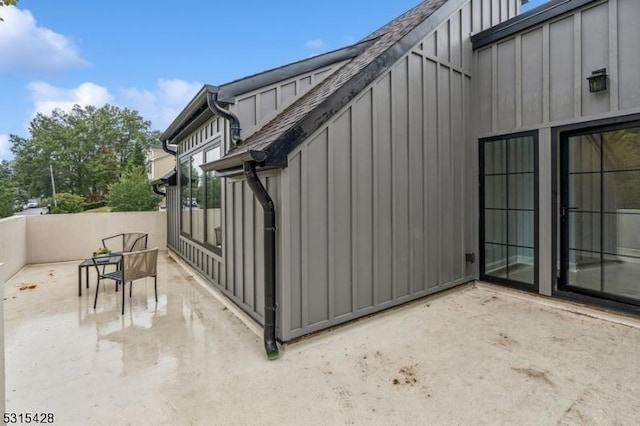 view of side of home with board and batten siding and a patio area