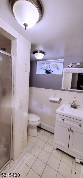 bathroom with toilet, an enclosed shower, tile patterned floors, a baseboard heating unit, and vanity