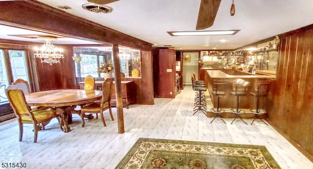 dining space with light wood-type flooring and bar