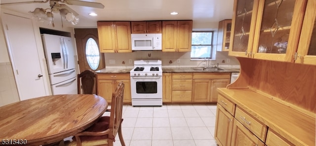 kitchen with light tile patterned flooring, ceiling fan, white appliances, sink, and backsplash