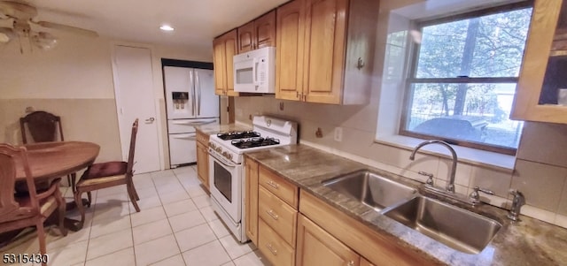 kitchen featuring ceiling fan, light tile patterned flooring, sink, white appliances, and backsplash