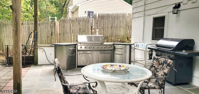 view of patio with an outdoor kitchen and a grill