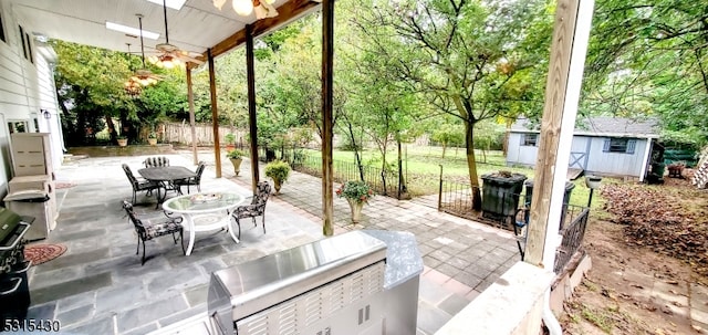 view of patio featuring ceiling fan and an outdoor structure