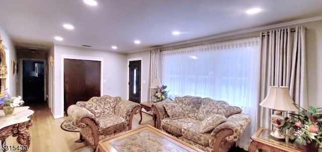 living room with light hardwood / wood-style floors and crown molding