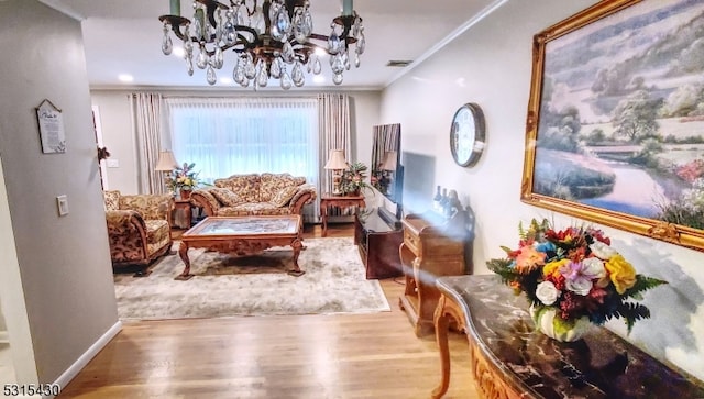 sitting room featuring ornamental molding, hardwood / wood-style flooring, and an inviting chandelier