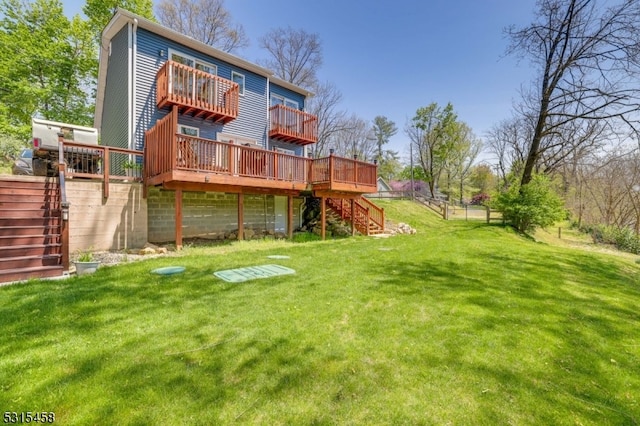 back of property featuring a wooden deck and a yard