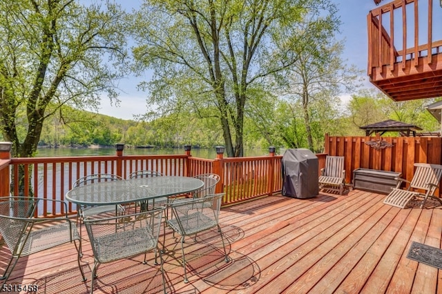 deck featuring grilling area, a gazebo, and a water view