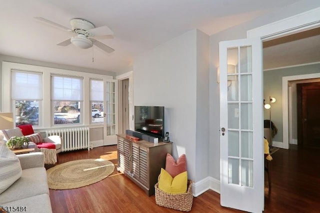 sitting room featuring baseboards, ceiling fan, wood finished floors, and radiator