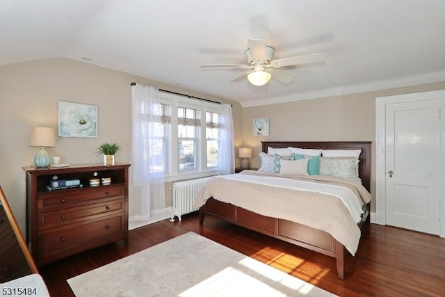 bedroom with dark wood-style floors, radiator, vaulted ceiling, and a ceiling fan