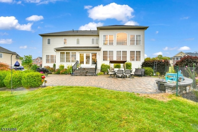 back of property with a patio and a lawn