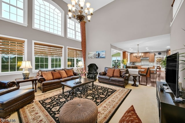 living room with an inviting chandelier, hardwood / wood-style floors, and a high ceiling