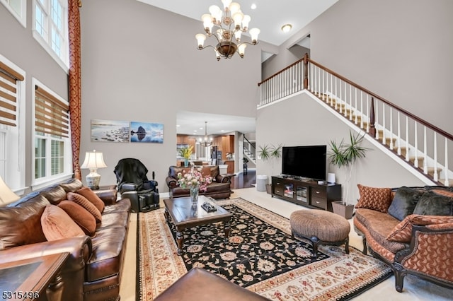 living room with a healthy amount of sunlight, a chandelier, and a high ceiling