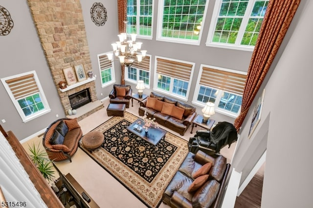 living room featuring hardwood / wood-style floors, a high ceiling, a notable chandelier, and a fireplace