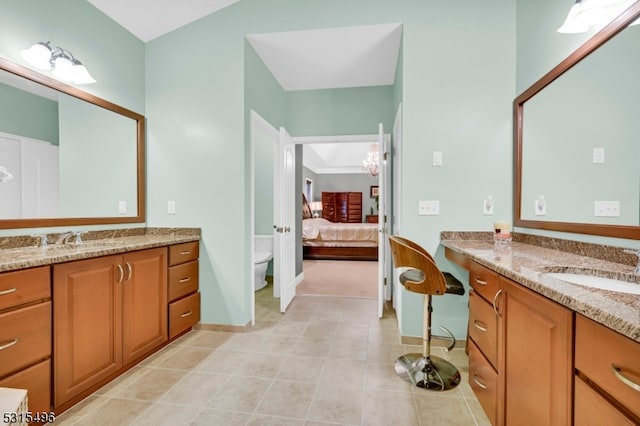 bathroom with toilet, vanity, and tile patterned flooring