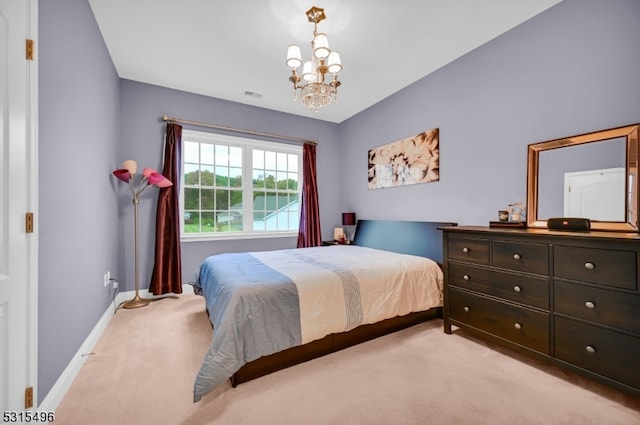 bedroom featuring an inviting chandelier and light colored carpet