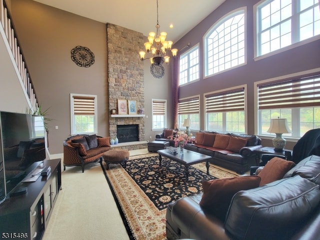 living room with a notable chandelier, a high ceiling, a fireplace, and carpet floors