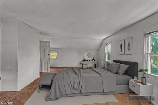 bedroom featuring lofted ceiling and light wood-type flooring