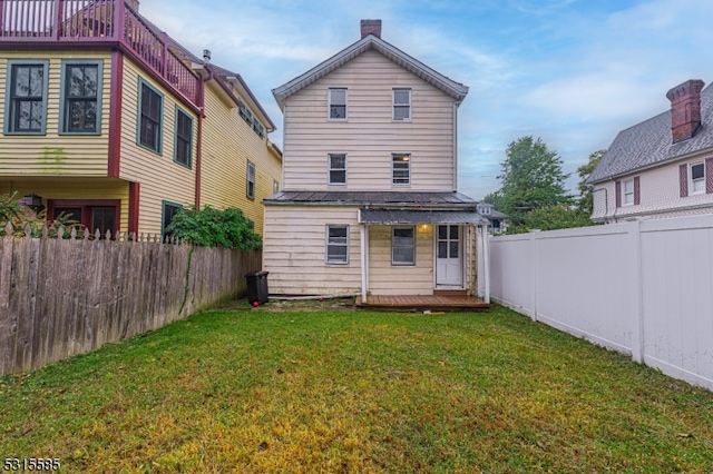 rear view of property with a lawn