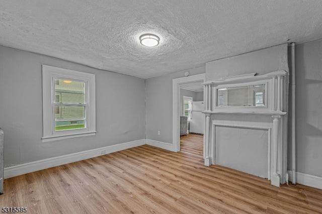 unfurnished living room featuring light hardwood / wood-style floors and a textured ceiling