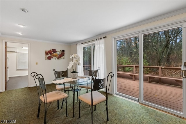 dining room with dark carpet and crown molding